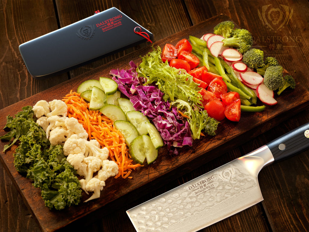 Different vegetables against a wooden surface beside a nakiri knife