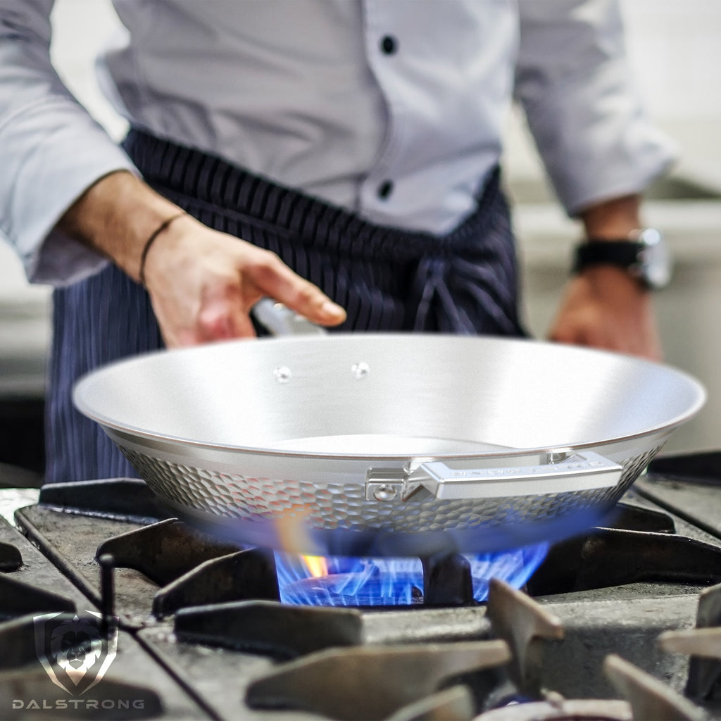 Stainless Steel frying pan over blue flames in a commercial kitchen