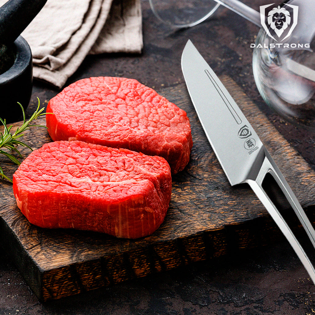 Raw Fillet Mignon on a cutting board next to a stainless steel steak knife