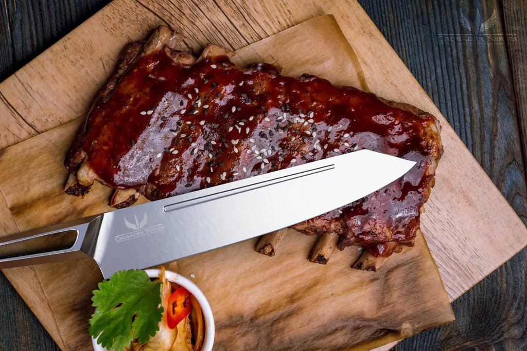 Chef knife laying on top of rack of ribs