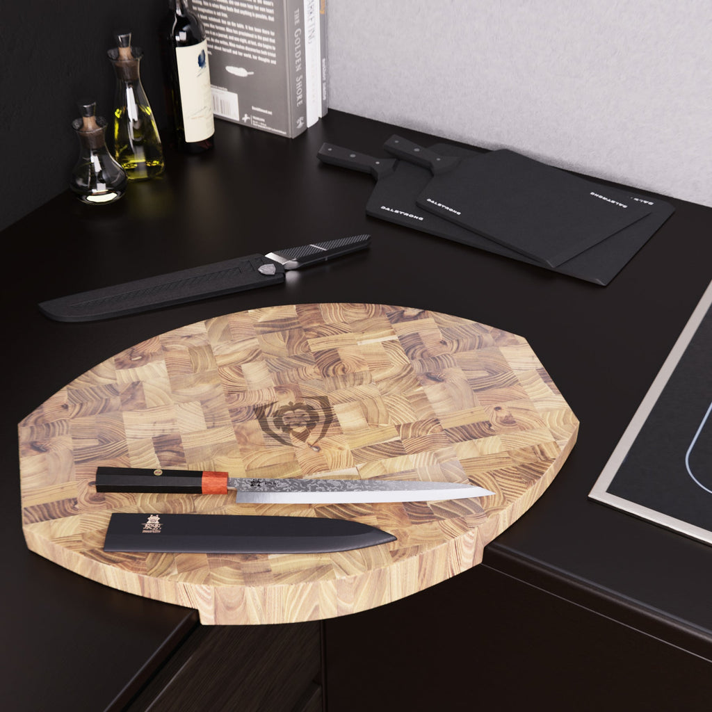 A black kitchen counter with a corner cutting board that has a kitchen knife on top of it