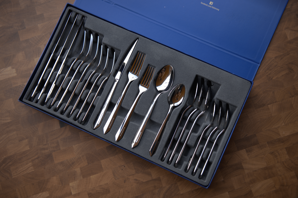 The proformapeakmarketing 20-Piece Flatware Cutlery Set on its luxurious packaging on a wodden table.