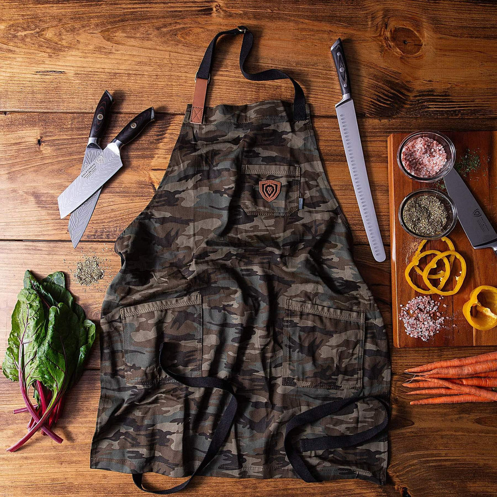 Green camouflage kitchen apron on a brown background next to chef knives and chopped peppers