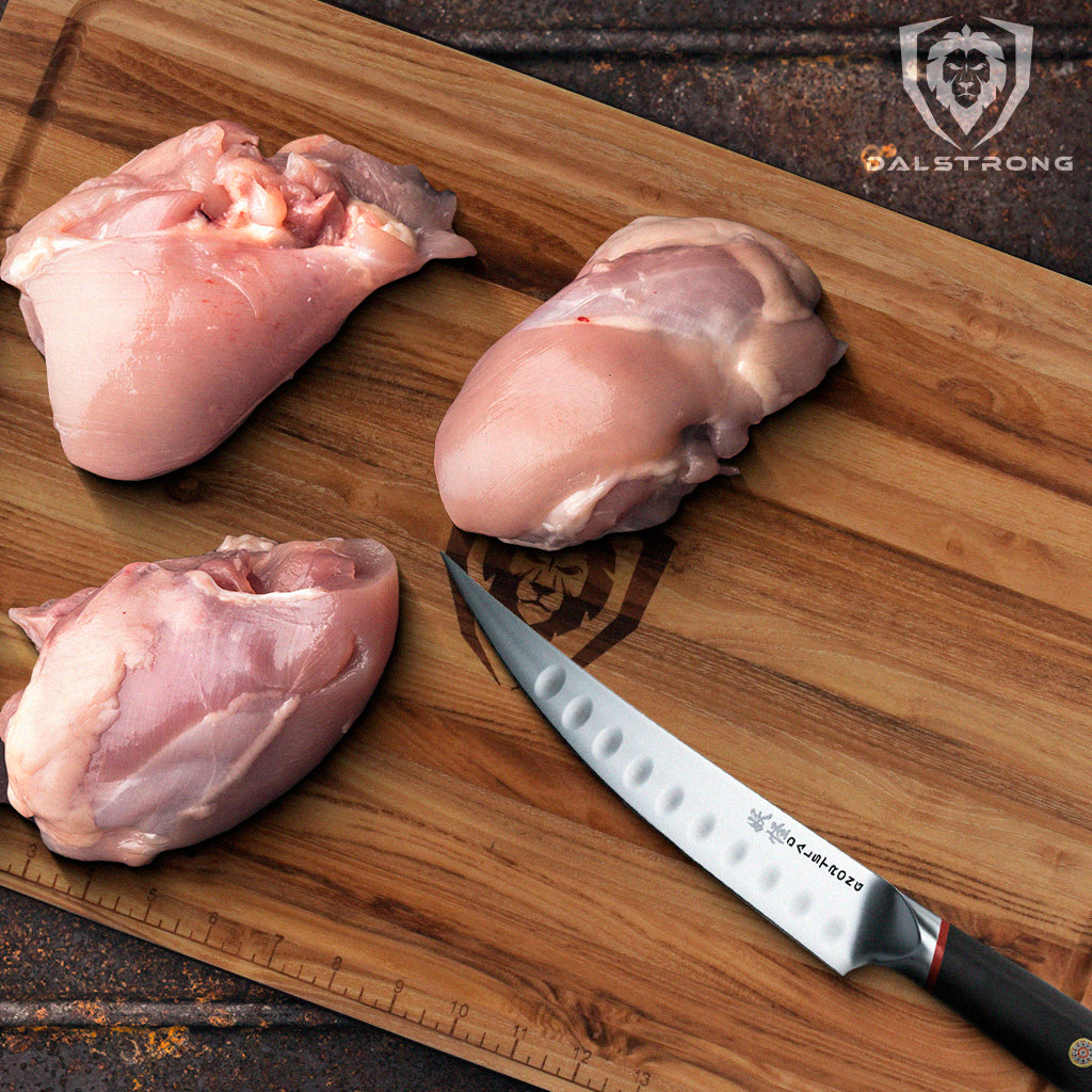 proformapeakmarketing Phantom Series Boning Knife beside three chicken thighs placed on top of a wooden cutting board.