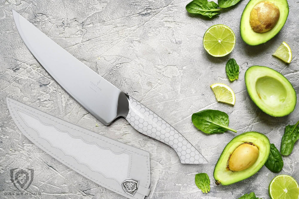 chef knife on marble table beside sliced avocado