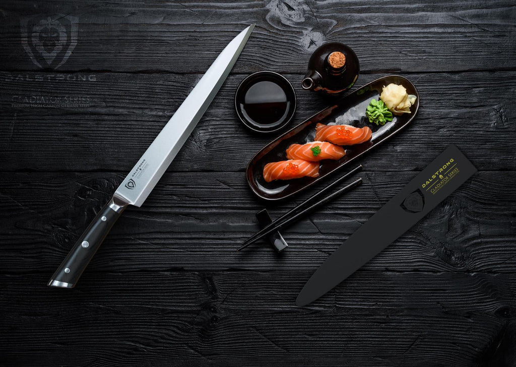 Yanagiba knife against a dark background next to sushi on a slim plate