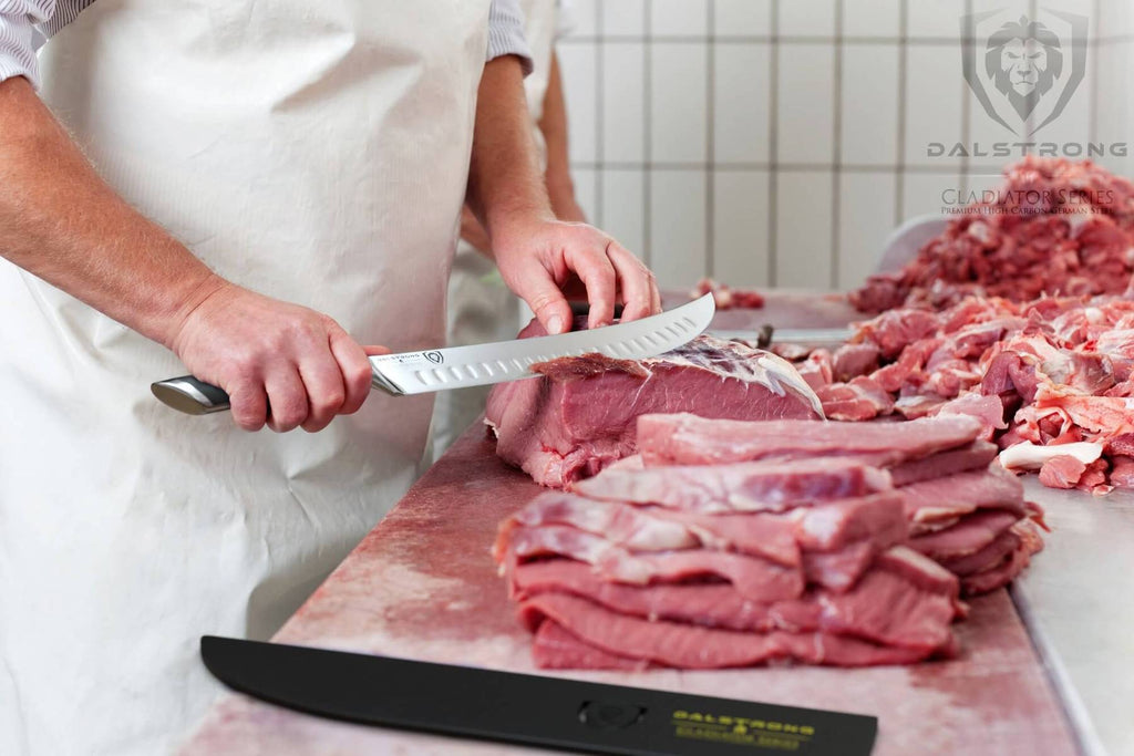 A butcher in a white apron uses a sharp butcher knife to slice raw meat