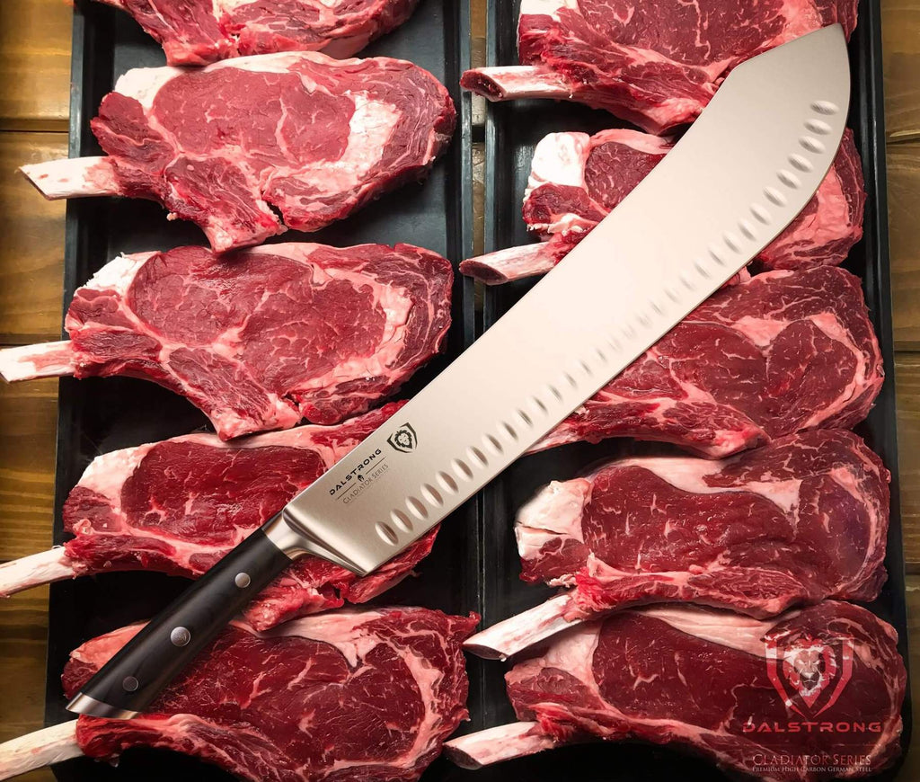 A large bullnose butcher knife resting on a bed of uncooked pieces of beef