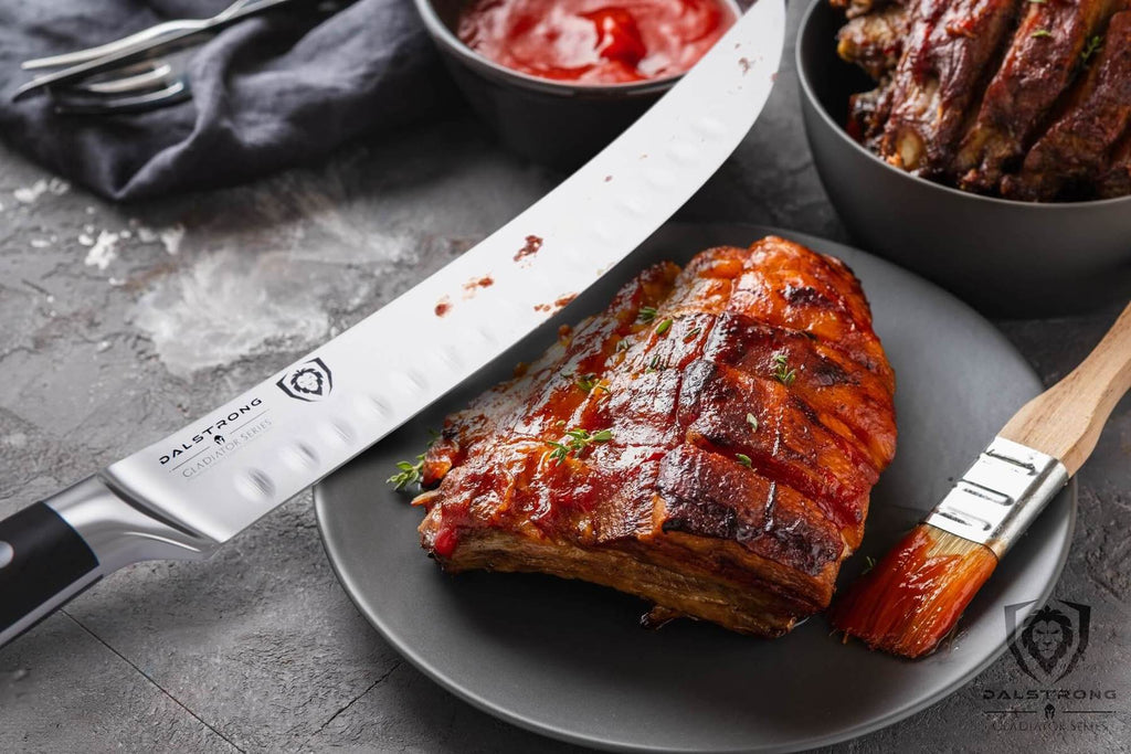 BBQ ribs on a plate next to a large butcher knife with sauce on the blade