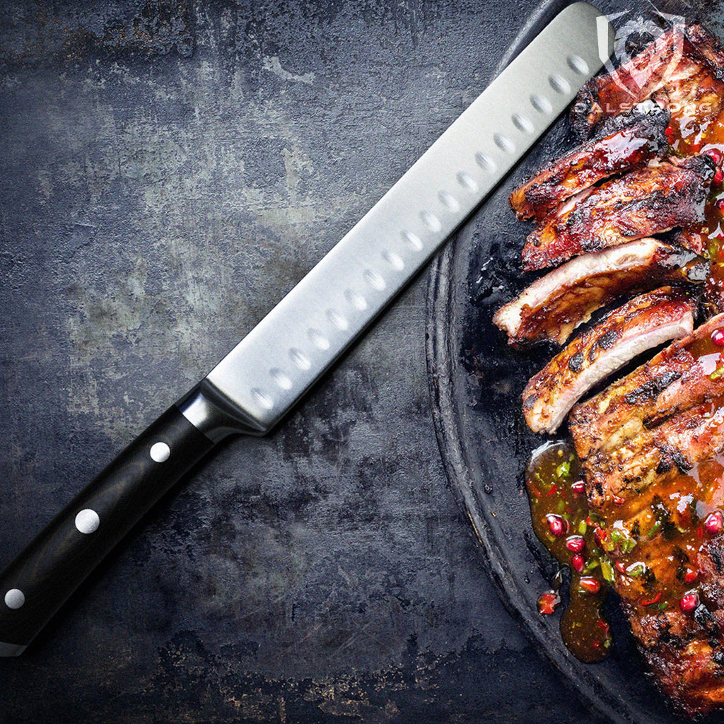 Carving knife with black handle next to a tray of cooked bbq ribs