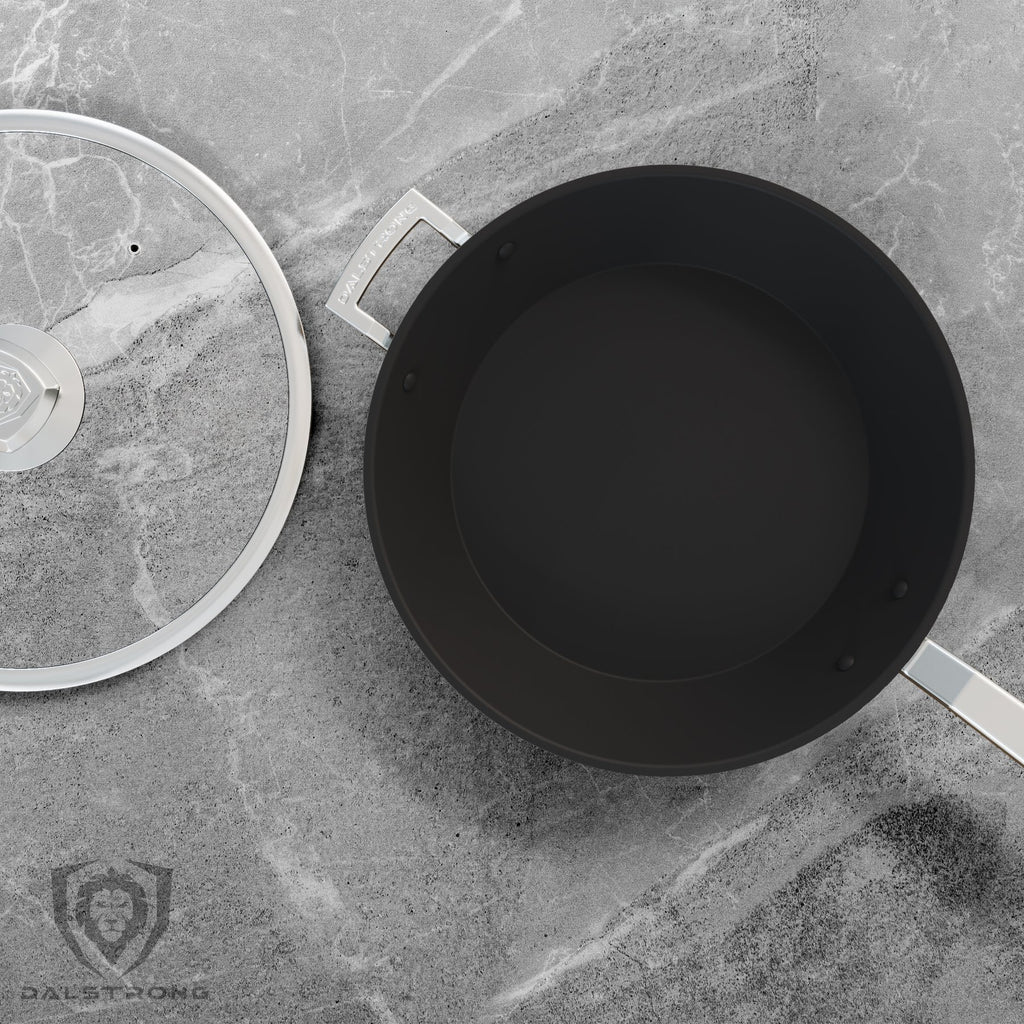 A black skillet with silver handles next to its own lid on a grey countertop