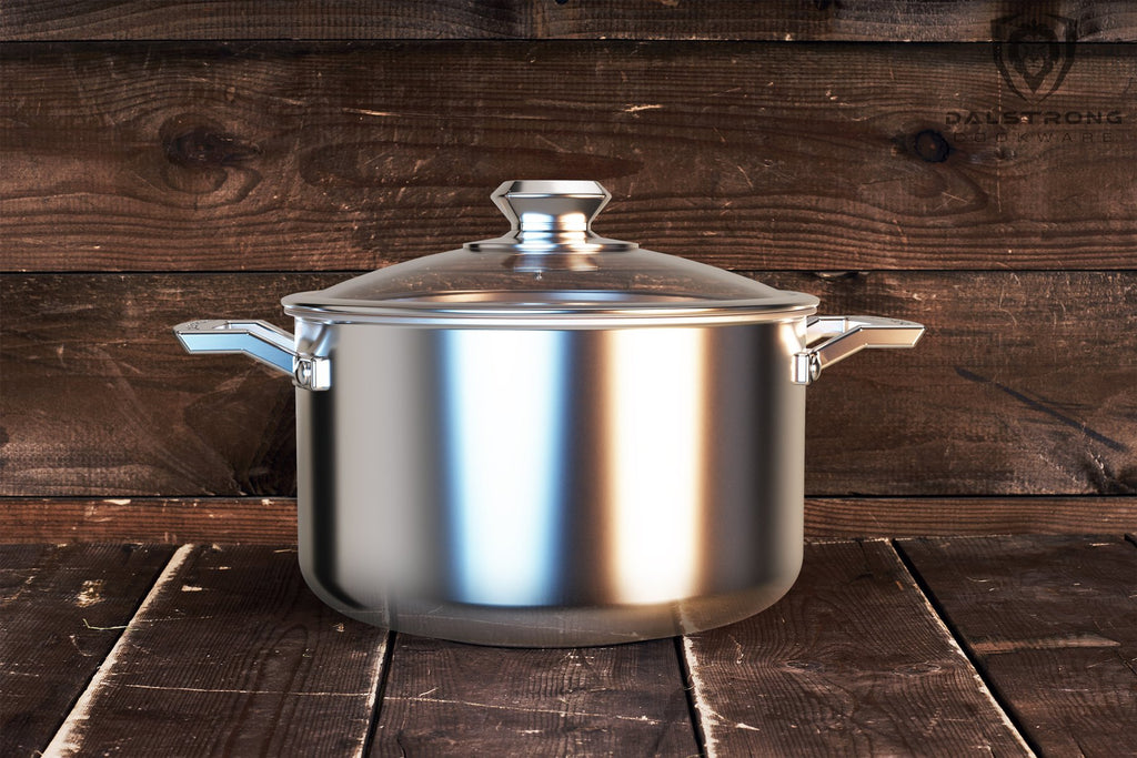 Large shiny silver cooking pot with lid against a dark wood background