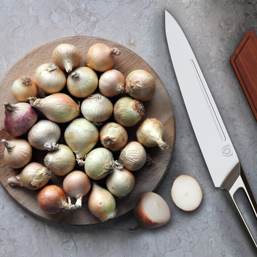 A plate of whole shallot onions next to a stainless steel kitchen knife