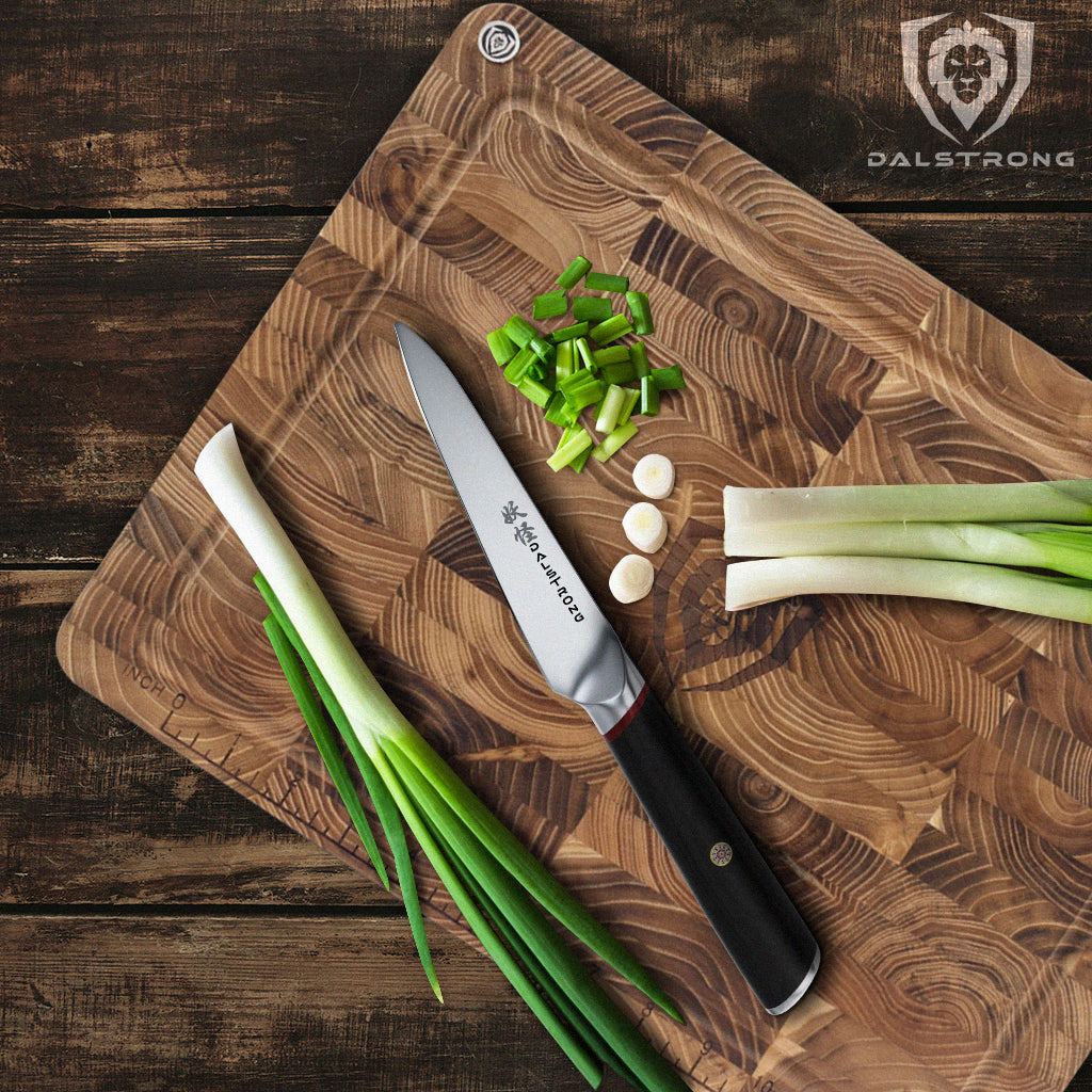 Chopped green onion on a cutting board next to a paring knife