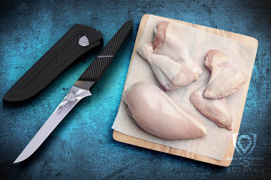 boning knife with raw chicken on cutting board