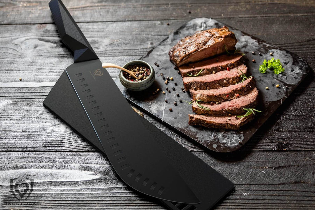 Black bull nose butcher knife next to sliced pieces of cooked meat