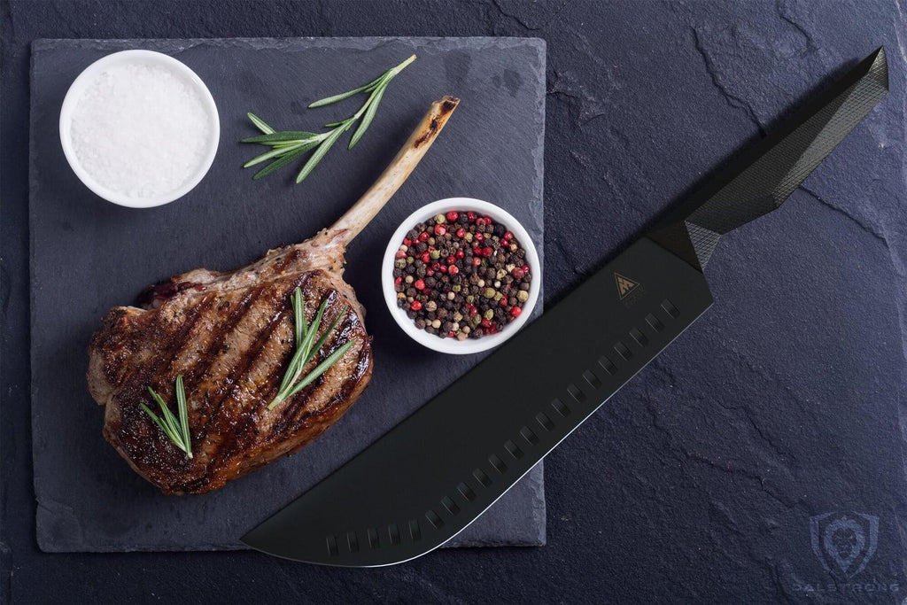 Large black butcher knife next to a cooked piece of meat on a dark background