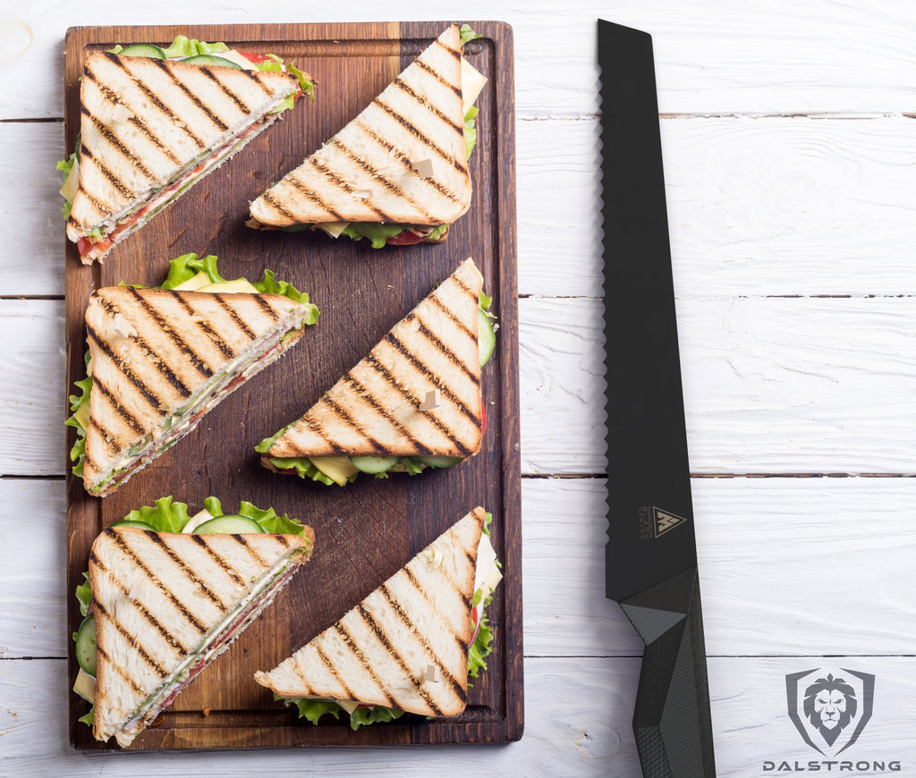 Shadow Black Series bread knife resting beside a tray of triangle shaped sandwiches on a cutting board
