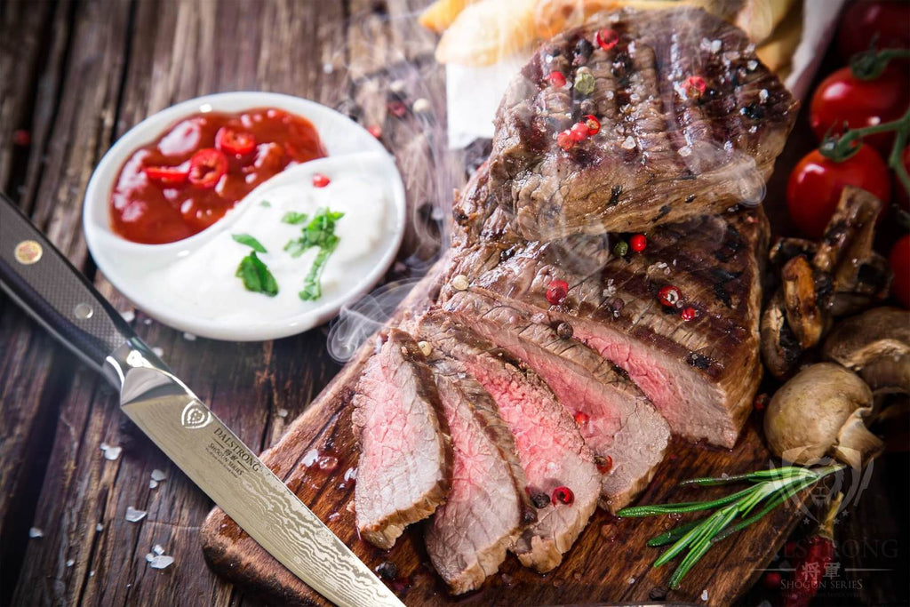 Steaming hot steak sliced on a cutting board next to garnish sauce and a sharp steak knife