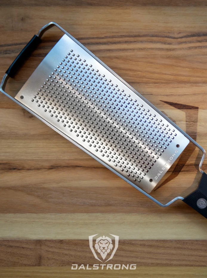 A photo of the proformapeakmarketing Professional Fine Wide Cheese Grater on top of the proformapeakmarketing wooden board.