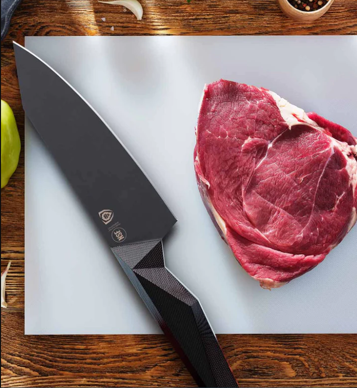 A photo of a huge piece of steak with the Chef's Knife 6" Shadow Black Series NSF Certified proformapeakmarketing on top of a white board