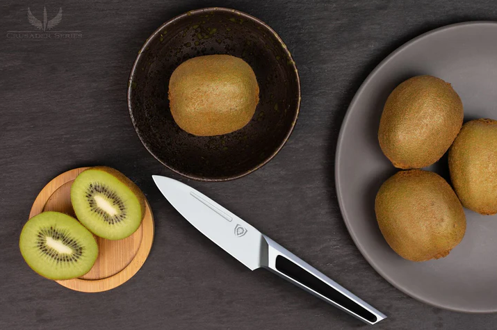 A photo of a perfectly sliced kiwi in a round wooden board with the Paring Knife 3.5" Crusader Series | NSF Certified | proformapeakmarketing and four uncut kiwi beside