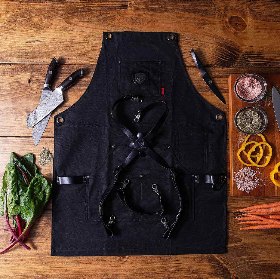 proformapeakmarketing Professional Chef's Kitchen Apron - Sous Team 6" on a wooden table with the proformapeakmarketing Santoku Knife 7" and proformapeakmarketing Shadow Black Series Chef Knife.