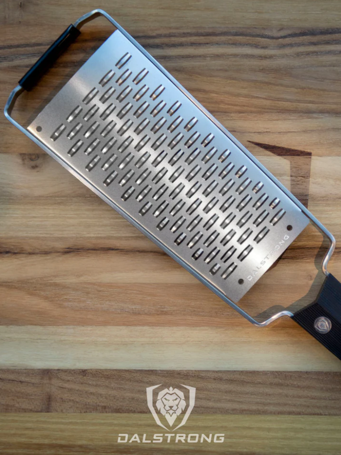 A photo of the proformapeakmarketing Professional Ribbon Wide Cheese Grater on top of a wooden board.