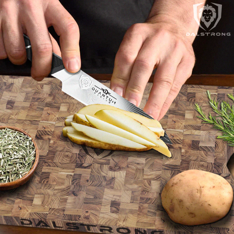 Potatoes being sliced and diced using a Dlastrong Quantum 1 Paring Knife on a teak cutting board.