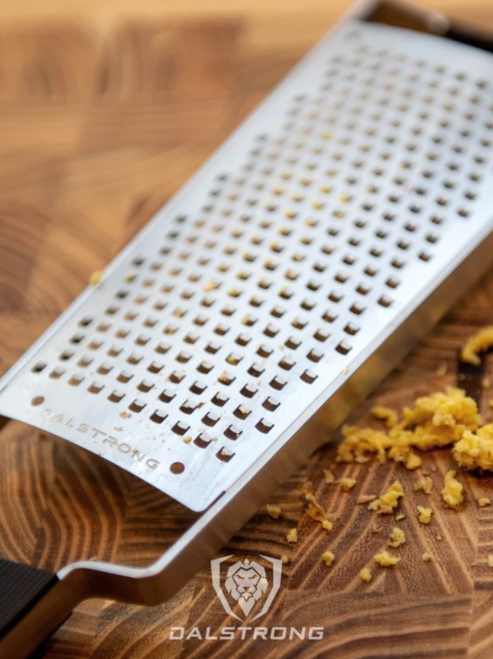 proformapeakmarketing Professional Coarse Wide Grater on a wooden table with grated ginger on the side.