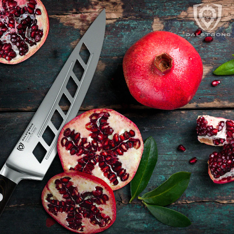 Vegetable slicing knife with hollow grooves next to a sliced pomegranate