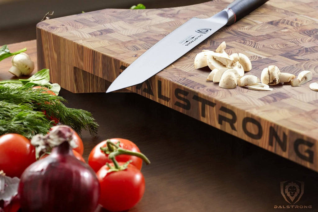 cutting board with knife beside veggies