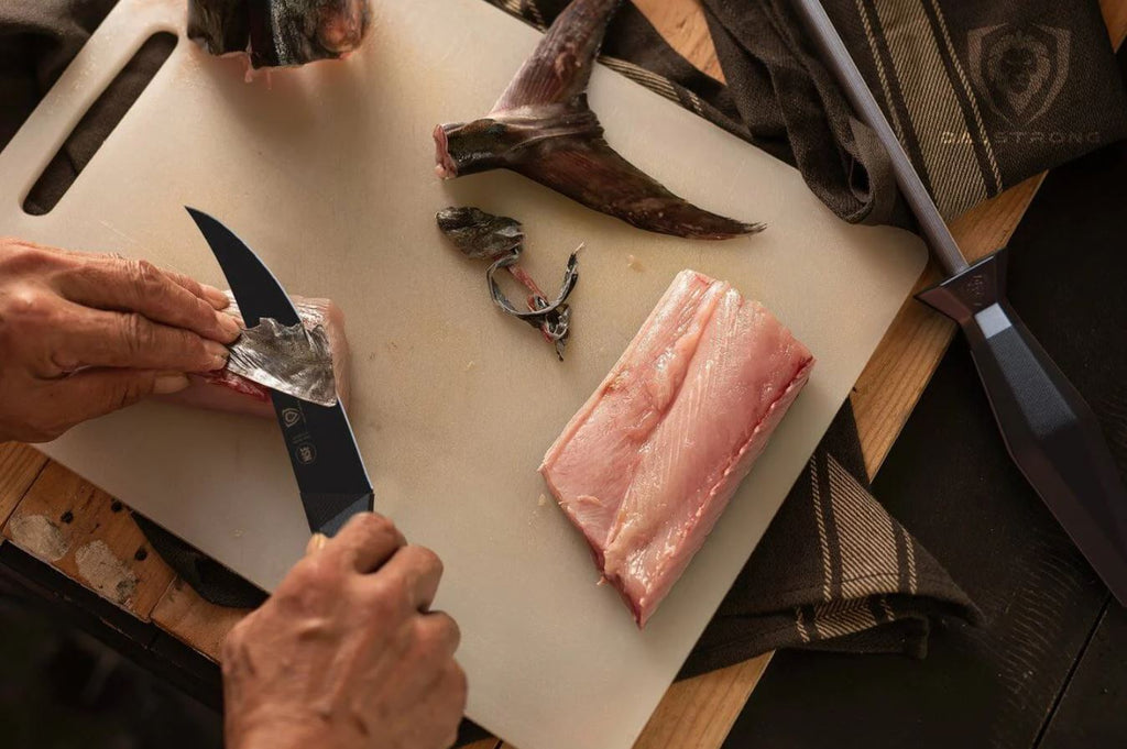 Slices of fish being filleted using proformapeakmarketing Shadow Black Series Fillet Knife on a white cutting board with a honing rod on the side.