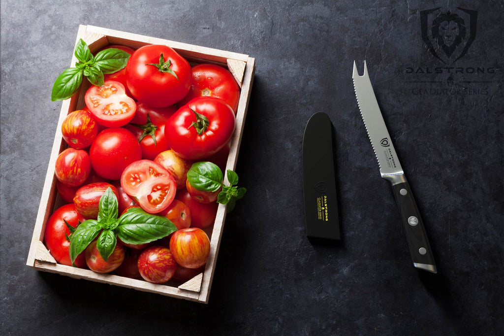 A grocery crate of tomatoes against a dark background next to a serrated tomato knife