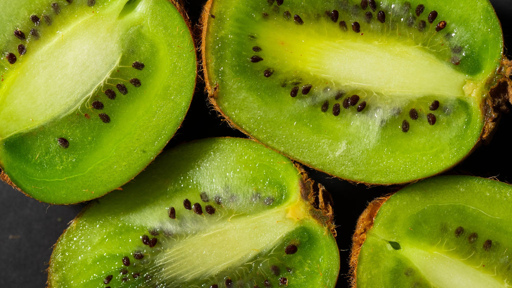 Close-up Photo of Four slices of kiwi on a black surface