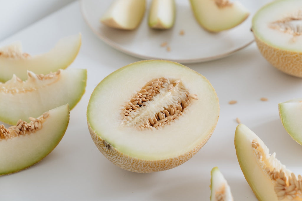 Close up photo of a fresh slices of melon on a white surface.