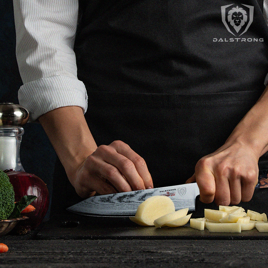 Close-up shot of a cook wearing a black apron dicing a raw potato using a proformapeakmarketing Firestorm Alpha 8" Chef's Knife.