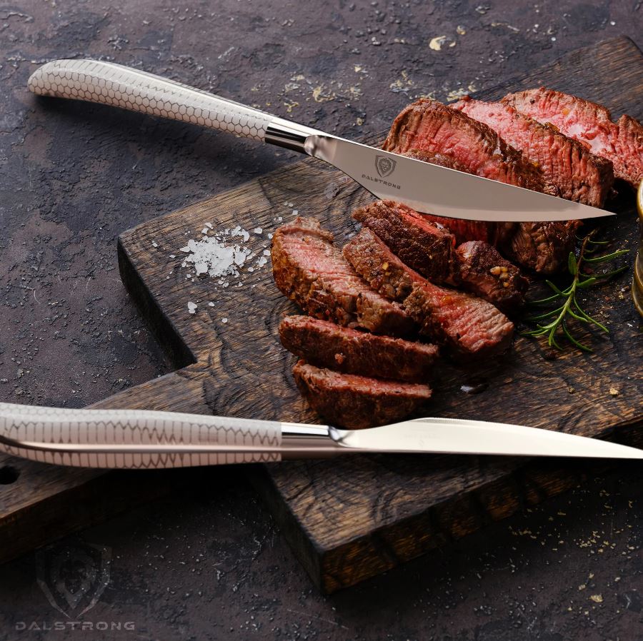 Frost Fire Steak Knives with slices of steak on top of a wooden shopping board