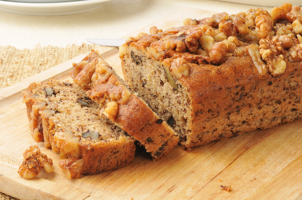 Banana bread seasoned with nuts on a brown cutting board