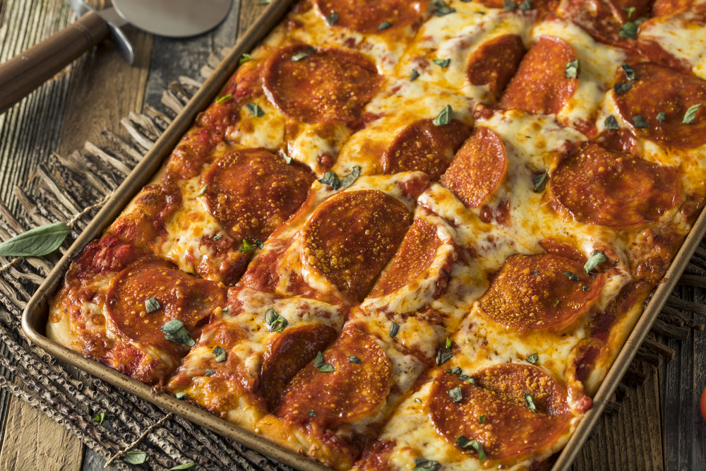 Sicilian Style pizza in a baking tray on a wooden table