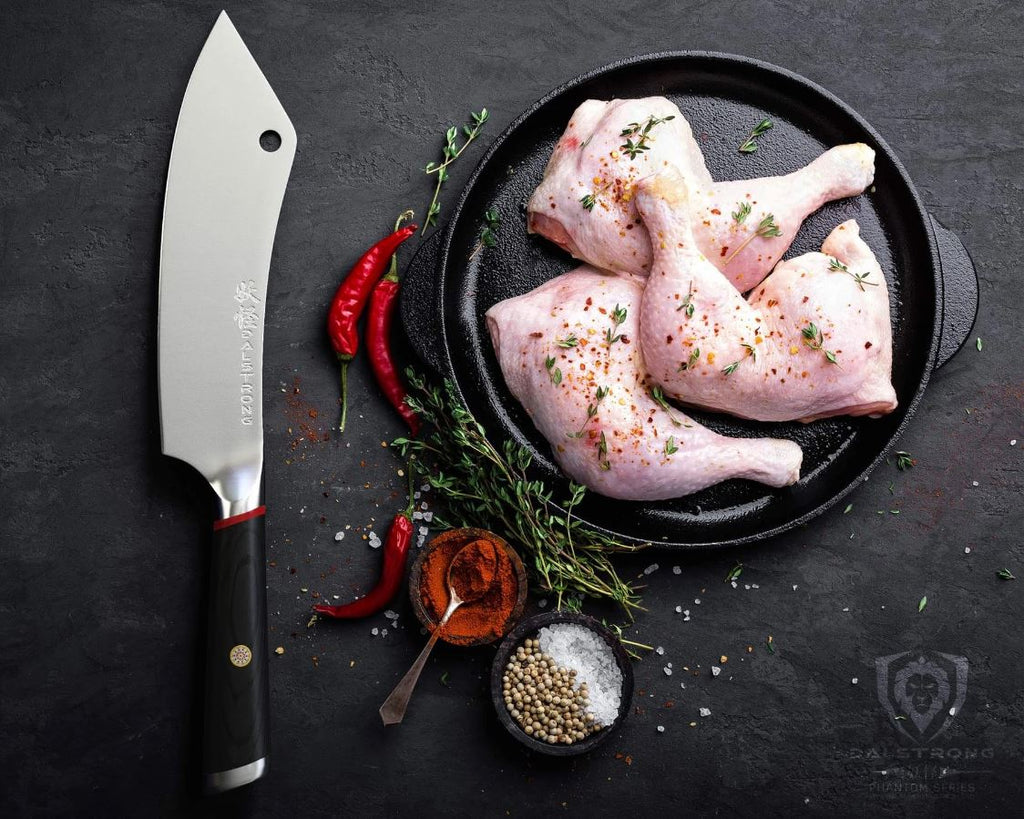proformapeakmarketing Phantom Series Crixus knife beside a plate full of raw cuts of chicken with herbs, chili, and seasonings on the side.