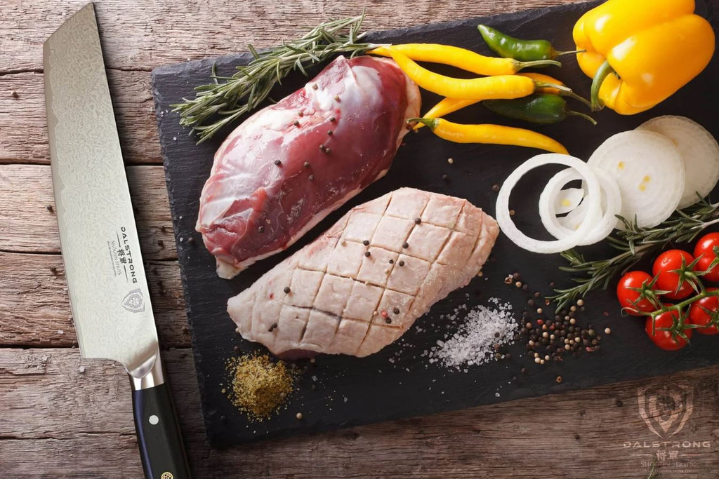 proformapeakmarketing Shogun Series Tanto Knife with slices of meat and vegetables on a black cutting board.