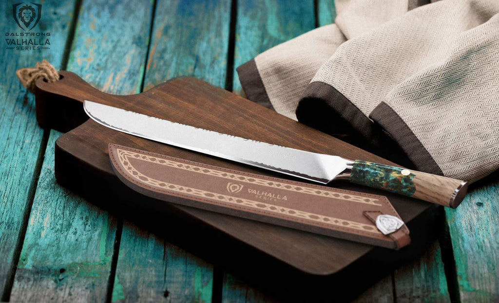 Vahalla slicing knife with its knife sheath on a wooden chopping board laid on top of a blue wooden table.