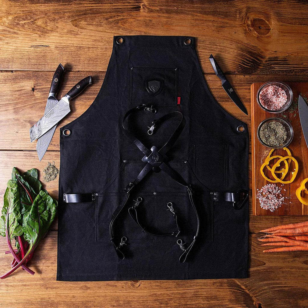 Heavy-Duty Waxed Canvas Sous Team Apron beside some knives and herbs.