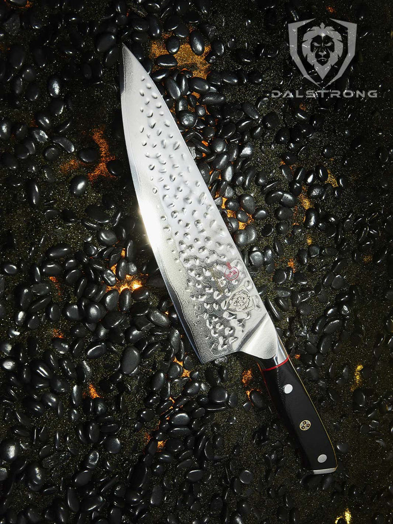 A photo of the Chef's Knife 8" | Shogun Series ELITE in a black sand with black pebble.